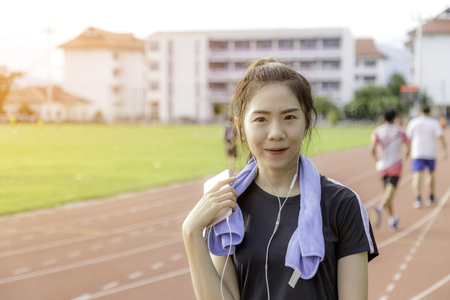 Asia girl listen music sear sportswear background public stadium with copy space.の写真素材