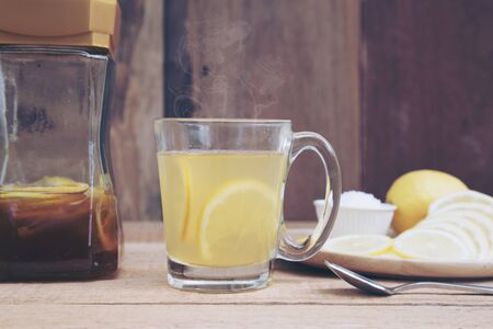 Hot lemon honey treatment healing the sick or flu from the cold made warm on wood table with copy space.の写真素材