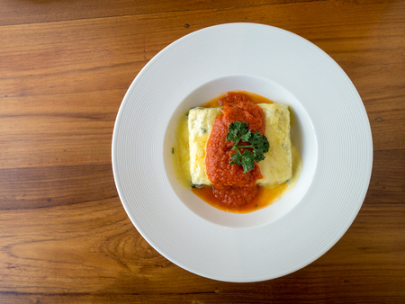 Spinach baked cheese in plate with copy space on wood table. top view.の写真素材