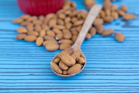 Almond nut on wooden spoon on wood background with copy space.の写真素材