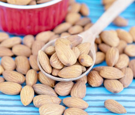 Almond nut on wooden spoon on wood background with copy space.の写真素材