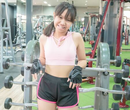 Asian teenage girl smile and relax after exercise in the gym.の写真素材