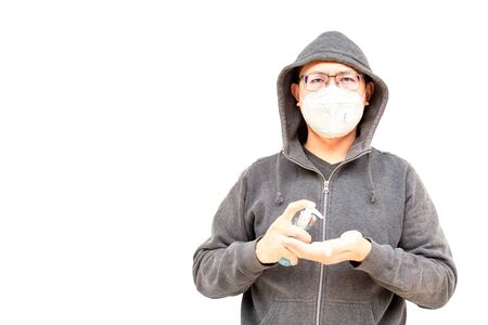 Asian middle age man Asia ethnic wearing a health mask and holding a hand wash gel to prevent virus or flu or covid19 or coronavirus and white background with copy space. Clipping path in the picture.の写真素材