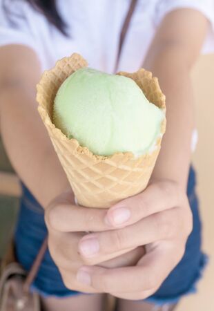 Asia teenage girl filed the green tea ice cream cone comes in front.の写真素材