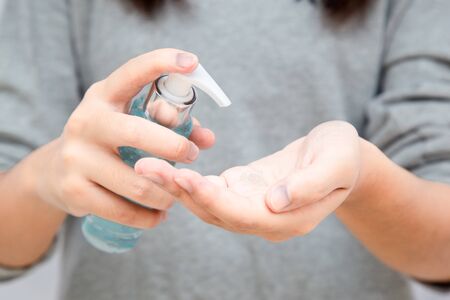 Asian teenage girls Asia ethnic holding an alcohol gel for hand washing to prevent viruses or coronavirus or covid-19 with white background.の写真素材