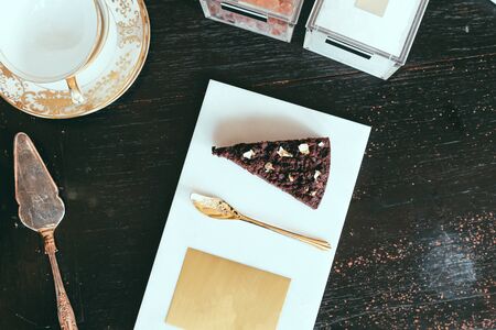 Chocolate cake on a marble plate and golden spoon in a restaurant. top view.の写真素材