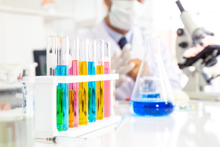 Test tube There is a liquid of various colors in it. The backdrop is a scientist experimenting with something in a laboratory.の写真素材