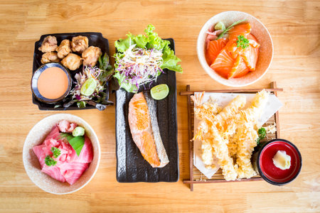 Indulge in the mouthwatering flavors of chicken karaage, shrimp tempura, salt-grilled salmon, and more, beautifully arranged on a wooden table. Elevate your culinary projects with these top-selling Japanese food photographs.の写真素材