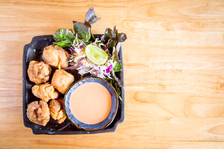 Capture the essence of Japanese cuisine with crispy karaage chicken on a rustic wooden table. A mouth-watering dish perfect for food blogs, menus, and designs.の写真素材