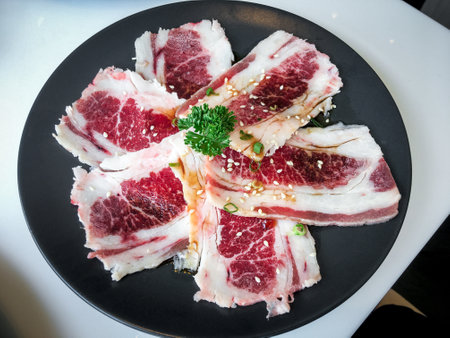 Experience culinary delight with savory sliced pork on a black plate. Indulge in a mouthwatering meal that satisfies every palate.の写真素材