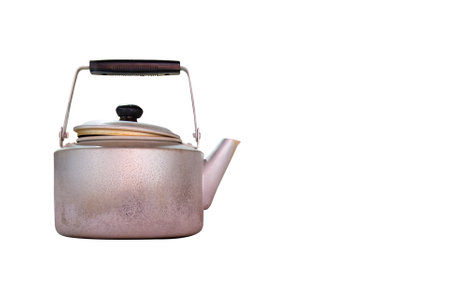 Antique kettle against white backdrop: Evoking nostalgia, this retro kitchenware embodies warmth and simplicity, reminiscent of cozy moments and cherished memories.の写真素材