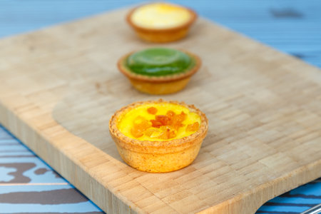Mango tart, Egg tart and Steamed custard tart on a wood with copy space.の写真素材