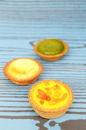 Mango tart, Egg tart and Steamed custard tart on a wood with copy space.の写真素材