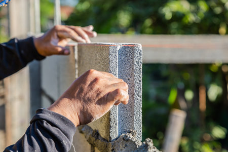 Worker masonry are building walls with cement blocks and mortar by building up in layers.の写真素材