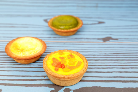 Mango tart, Egg tart and Steamed custard tart on a wood with copy space.の写真素材