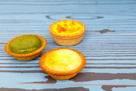Mango tart, Egg tart and Steamed custard tart on a wood with copy space.の写真素材