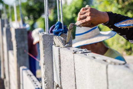 Worker masonry are building walls with cement blocks and mortar by building up in layers.の写真素材