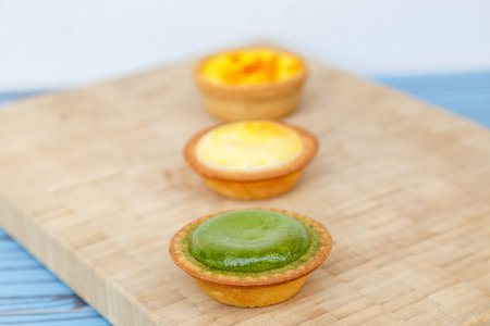 Mango tart, Egg tart and Steamed custard tart on a wood with copy space.の写真素材