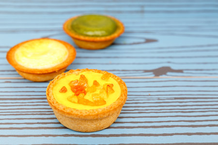 Mango tart, Egg tart and Steamed custard tart on a wood with copy space.の写真素材