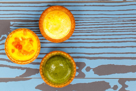 Mango tart, Egg tart and Steamed custard tart on a wood with copy space. top view.の写真素材