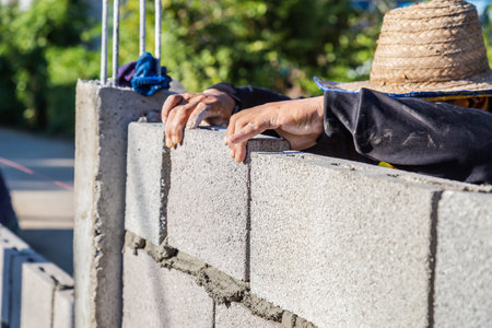 Worker masonry are building walls with cement blocks and mortar by building up in layers.の写真素材
