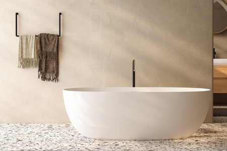 Stylish white bathtub on terrazzo floor with back faucet in bright bathroom, beige and white wall background. 3d renderingの写真素材