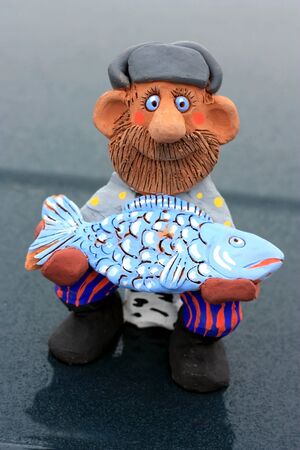 Fisherman holding a fish caught. Russian folk character Emelyaの写真素材