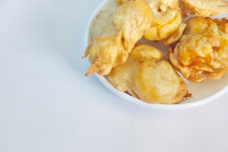Indonesian style fried banana in a small bowl on a white background, traditional snacksの写真素材
