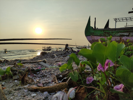 silhouette of a ship anchored on the beach at sunset