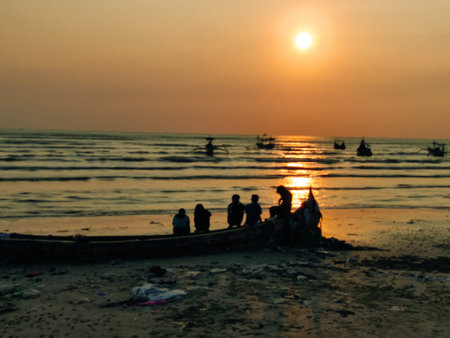 silhouettes of people playing on the beach at sunset