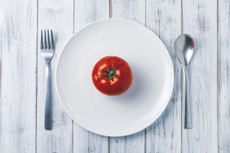 Tomatoes, forks and spoonsの写真素材
