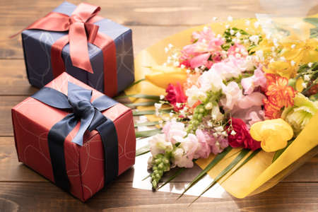 Bouquets and gifts on a wood grain backgroundの写真素材