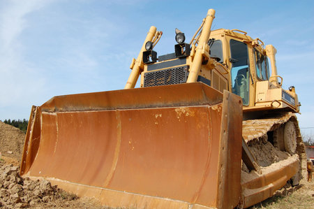 A bulldozer with rust blade afer a rainy weekend.