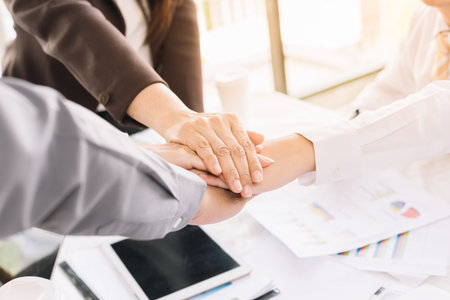 Professional business people show their unity by putting their hands together.Concept of teamwork.