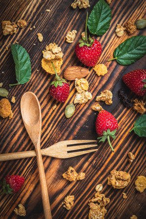 Top view berry fruit and cranola grains placed on a wooden floor with a spoon, Vegetarian or Healthy...
