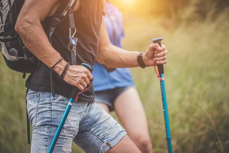 Adventure themed travel and hiking trips, Close up hands of the hikers are helping to climb the mountain as a team.Group of friends that are happy and fun to travel.の写真素材