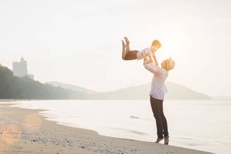 Happy family with little boy walking together on a tropical beach during the summer holidays. Father and son walking on the beach in the morning. vacation day.の写真素材