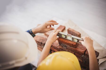 Educational concepts and child engineer - Top view hand of the little boy were learning to put bricks in layers with father teach. Father and son play together fun in the home.の写真素材