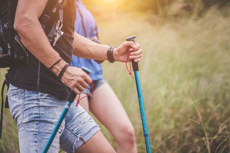 Adventure themed travel and hiking trips, Close up hands of the hikers are helping to climb the mountain as a team.Group of friends that are happy and fun to travel.の写真素材