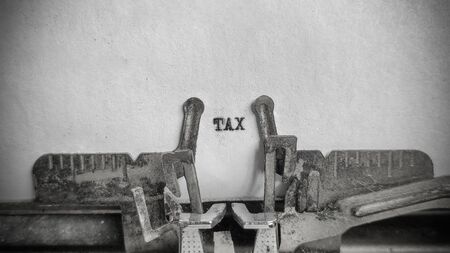 TAX text on blank sheet with an old typewriter in vintage backgroundの写真素材