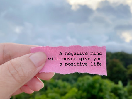 Motivational quote on pink torn paper with blue sky background.の写真素材