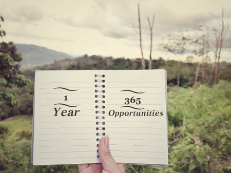 Vintage tone, Hand holding a notebook with text and nature backgroundの写真素材