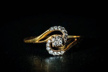 Macro shot of a golden diamond ring in a dark backgroundの写真素材