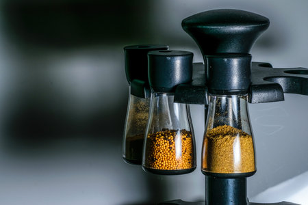 Transparent containers containing mustard seeds, coriander powder and cumin powder