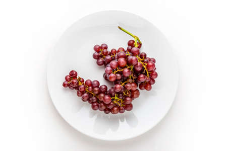 A bunch of grapes on white plateの写真素材