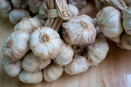 Pile of white garlic heads on wood backgroundの写真素材