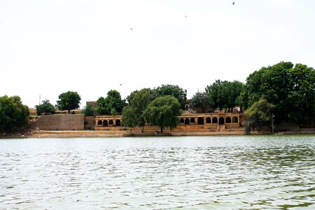 historical gateway building in yellow sandstone on lake shoreの写真素材