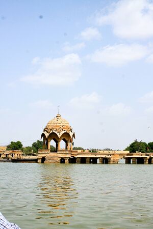 historical gateway building in yellow sandstone on lake shoreの写真素材