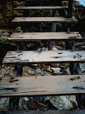 Close up Old Wooden Ladder on the Cliffの写真素材