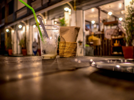 plastic cup of water and tissue on the wooden table in restaurant,Food conceptの写真素材